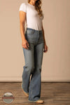 Woman wearing a white t-shirt and blue flared jeans on a beige background Kimes Ranch WJE0000016 Olivia light wash front