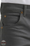 Close-up of gray pants with gold buttons and a visible brand logo. Wrangler 112361474 Premium Performance Tough Comfort Cowboy Cut Slim Fit Canvas Jean in Grey Pinstripe front pocket view