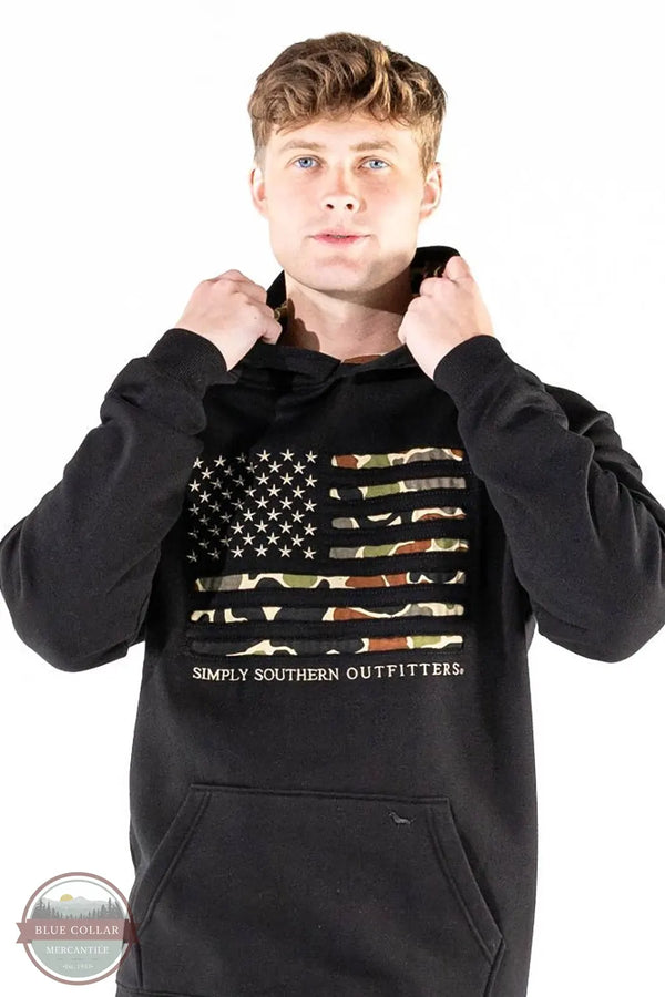 Simply Southern 0226-MN-HD-OTDR-BLACK Camo Flag Hoodie in Black on model with white background