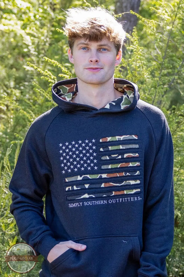 Simply Southern 0226-MN-HD-OTDR-BLACK Camo Flag Hoodie in Black on model outside, front shown