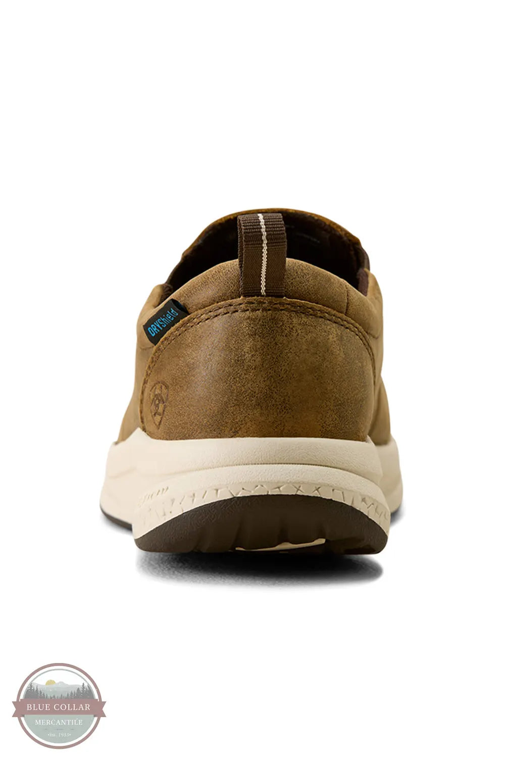 Ariat's 10080297 Women's Buckeye Slip On Waterproof Shoe in Brown Bomber, A single brown suede slip-on shoe shown from the back on a white background, featuring a cream-colored midsole and a small blue-green brand tag on the heel.