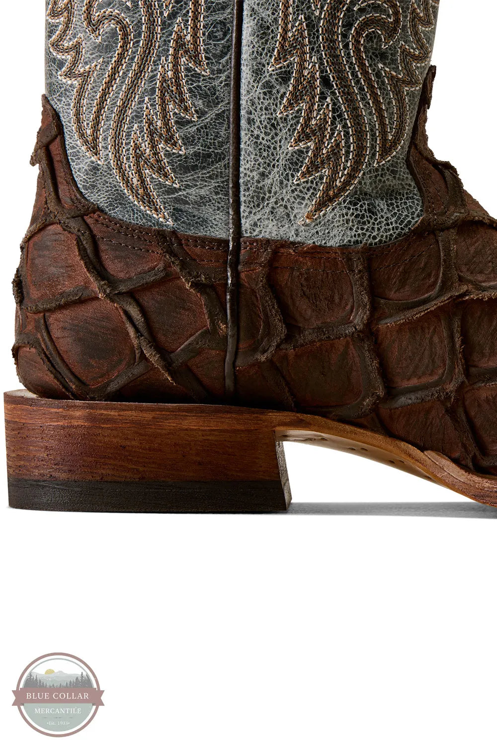 Ariat's 10080345 Men's Riverside Exotics Print Square Toe Western Boot in Chocolate Bass Print / Indigo Honor Blue, Close-up of a brown leather cowboy boot showing the textured crocodile-embossed side panel, wooden heel, and part of the western embroidered shaft on a white background.