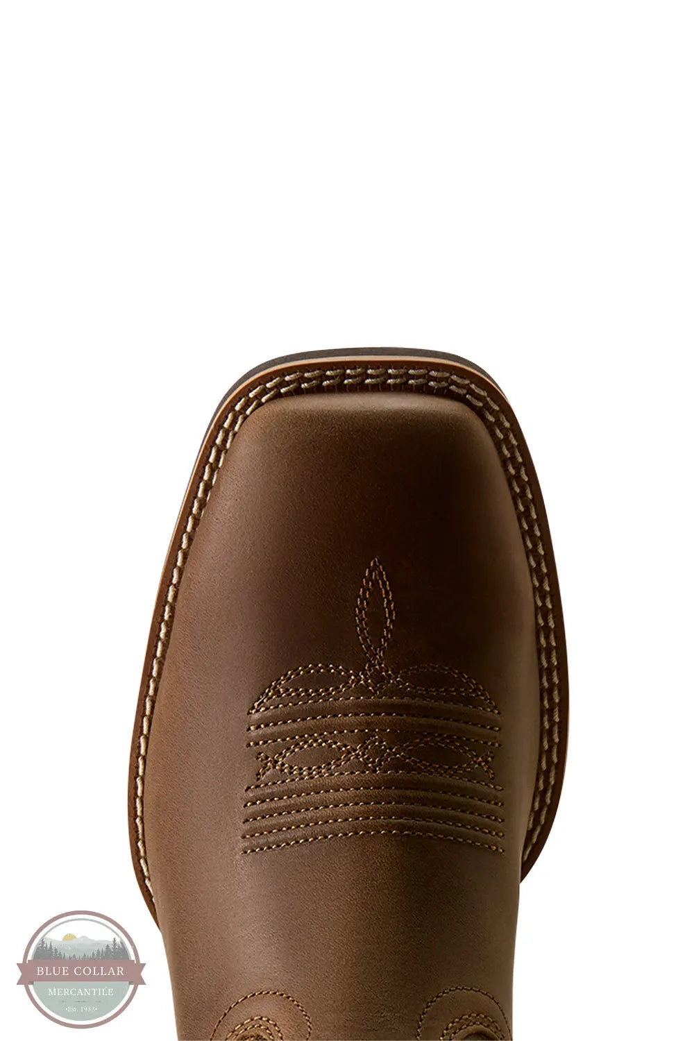 Ariat's 10080535 Men's Arrowrock Wide Square Toe Cowboy Boot in Bronzed Mocha / Tobacco Tan, Close-up of the toe and vamp of a brown leather western boot with decorative stitching and embossed detailing, shown on a white background.