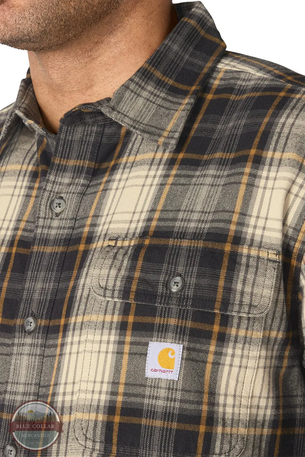 Carhartt 107013-N04 Men's Hubbard Loose Fit Long Sleeve Flannel Plaid Shirt, Close-up of a man wearing a Carhartt plaid button-down shirt. The shirt features a pattern of dark gray, beige, and mustard yellow.