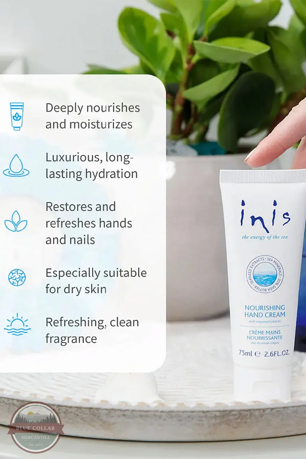 Inis 8015556 Nourishing Hand Cream 2.6FL. OZ. A hand holds an Inis Nourishing Hand Cream tube next to a white informational card highlighting product benefits, with a blurred green potted plant in the background.