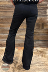 Judy Blue 881177REG High Waist Black Jaqueline Flare Jean With Lace, Black flare jeans with lace-up side details, shown from the back on a model standing on a brown hide rug against a rustic wooden wall.