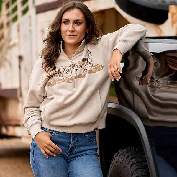 Fall 2026 Apparel available at Blue Collar Mercantile The workingman's Store in Winchester, VA woman in a pullover sweater leaning on vehicle in ariat