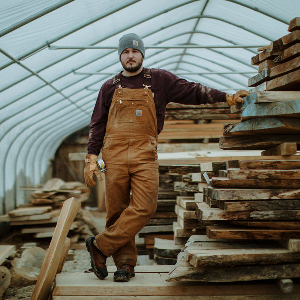 Carhartt 102776-211&nbsp;Relaxed Fit Duck Bib Overall in Carhartt Brown image of worker wearing it