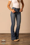 Person wearing blue jeans and a white top on a wooden floor with a beige wall background Kimes Ranch WJE0000008 Jennifer Jeans Mid Wash front view
