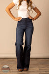 Person wearing blue jeans and a white shirt against a beige wall. Kimes Ranch WJE0000016 Olivia dark wash front
