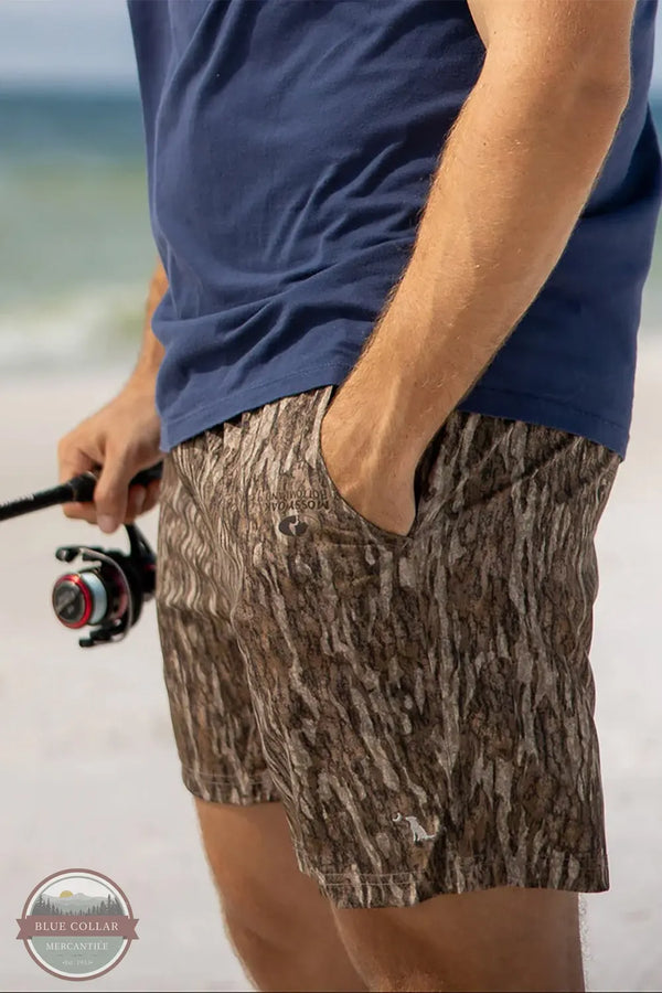 Local Boy Outfitters L1600015-BLD Men's Volley 6" Shorts in Mossy Oak Bottomland Camo lifestyle image of man fishing