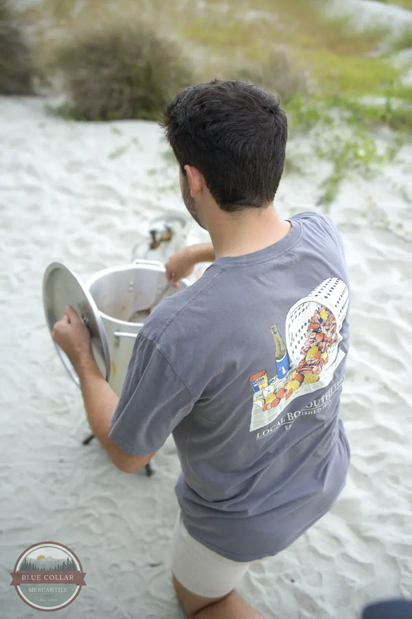 Local Boy Outfitters Low Country Boil T-Shirt L1000744-GRY lifestyle image showing man on beach cooking