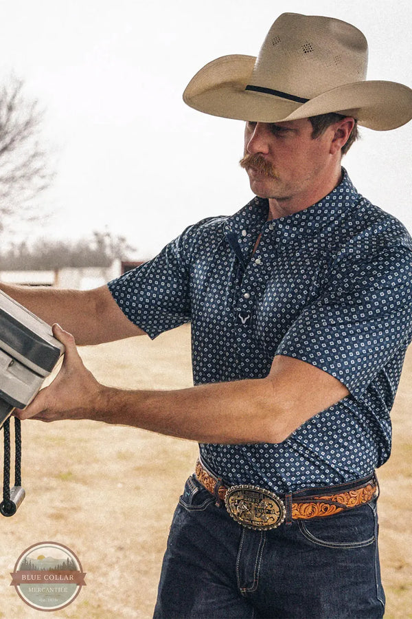 Vexil Brand – Western Pearl Snap Polo - Tribal Board | Navy lifestyle image of cowboy working in Vexil Polo